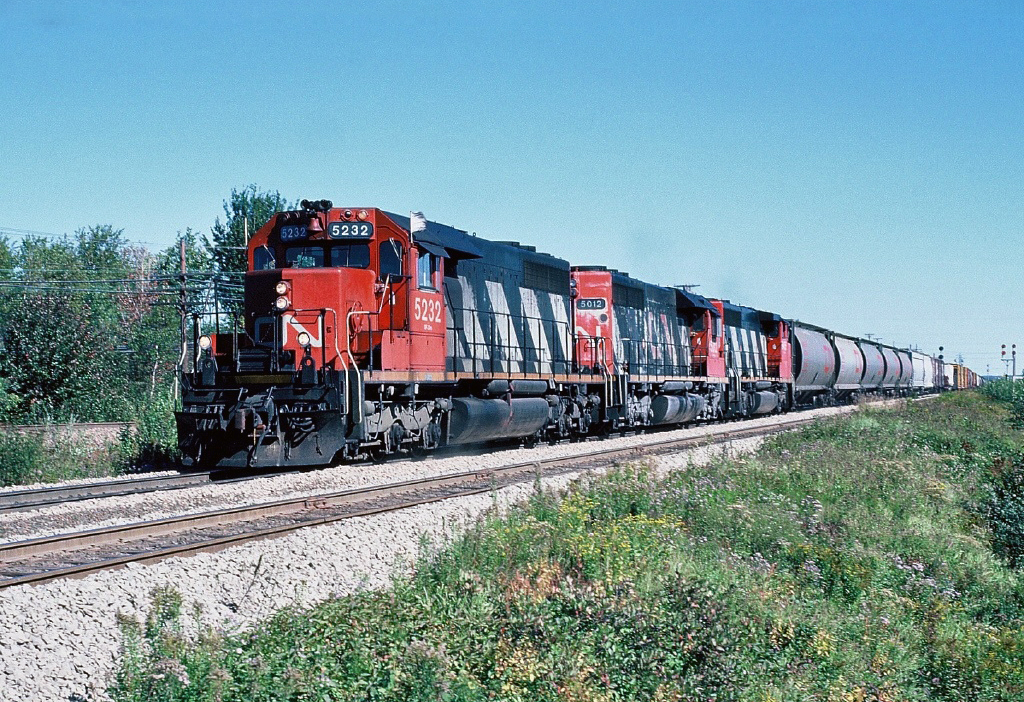 Westbound CN SD40 5232 and 5012 with GP40-2LW 9565 drifts into Moncton and on to Gordon yard for a crew change. Sept. 25, 1988.
