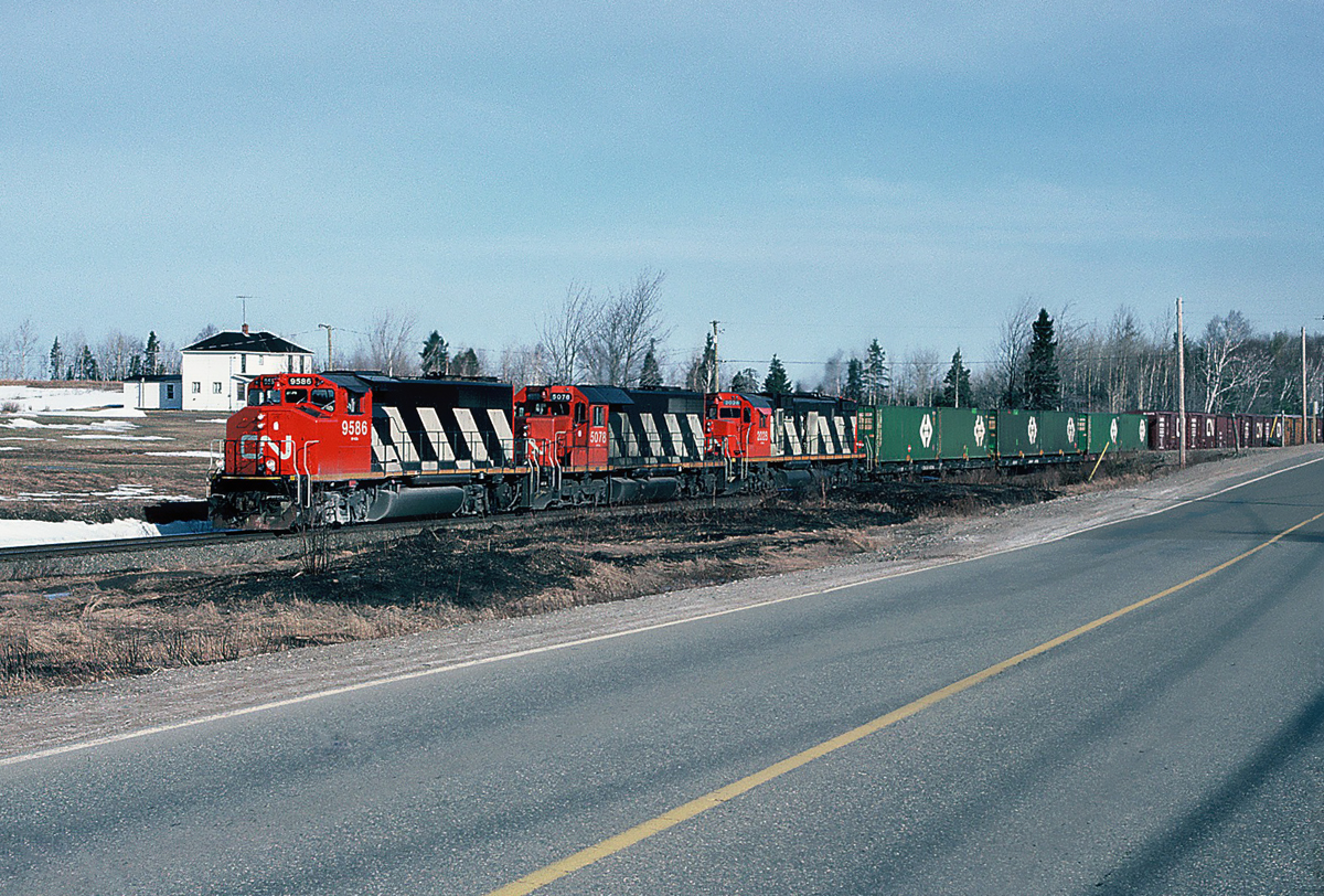 CN GP40-2LW 9586, SD40 5078 and MLW C-630M 2028 eastbound near Rogersville, New Brunswick. April 20, 1991.