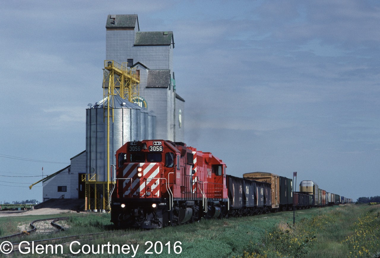 CPR GP38-2 3056 is leading Winnipeg - Emerson train #560 past the Manitoba Pool elevator at Fredenstahl West on the outskirts of Emerson. I believe that this elevator has been demolished. #560 exchanged cars with both Burlington Northern and Soo Line at the border (Emerson, MB / Noyes, ND).