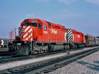 A westbound auto rack train with a pair of SD40s 5520 and 5504 as stopped for a crew change at CP's Agincourt yard. October 23, 1987. 