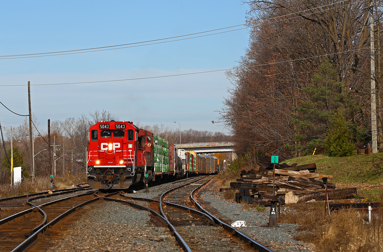Sometimes it's better to be lucky than good. Witness the leader on CP 235, at Woodstock, ON, on a sunny but very windy autumn day. Almost two years since I've seen anything but GE's on this train, a chance encounter with SD30C-ECO #5043 in the lead was a nice surprise. Here the train is waiting for the conductor to finish his (very long) walk back to the head end after making a mid-train lift out of Coakley siding. These days, 235 is a westbound "land-barge" with its' usual Montreal-Detroit intermodal cars, but also (in this case, as usual) head-end traffic for London, autoracks lifted at Coakley, the stack cars, and a long cut of autoracks lifted from Wolverton. Quite often the train is well over 10,000 feet out of Woodstock. NOTE: Photo taken from grade crossing; the train had shoved far enough to exit the crossing timing circuit and was stationary at time of photo.