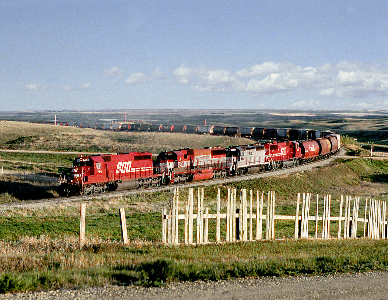Grain loads from Assiniboia to Moose Jaw assault the grades of the Cactus Hills in throttle 8. The train with all foreign power approaches the crest of the Missouri Coteau ridge