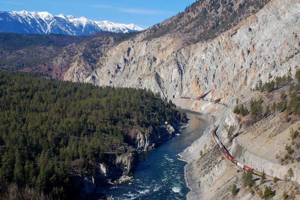 There have been a lot of shots taken at this location in the Thompson canyon, but when the weather is this good it's hard to resist taking another one. CP 9775 is leading a westbound load of grain through the rock sheds and in the distance the snow capped mountains mark the west side of the Fraser valley.