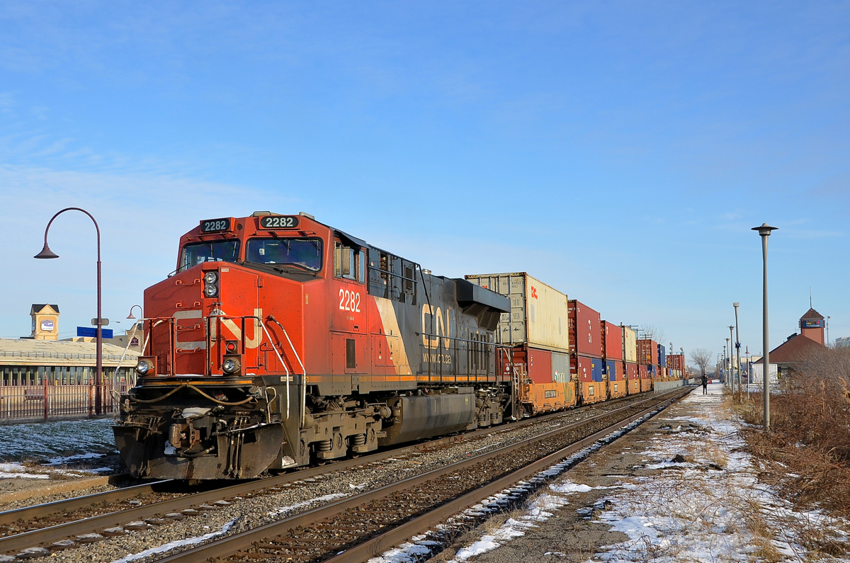 CN 2282 is shoving on the rear of CN 106 which is passing VIA's Dorval Station on a sunny winter afternoon.
