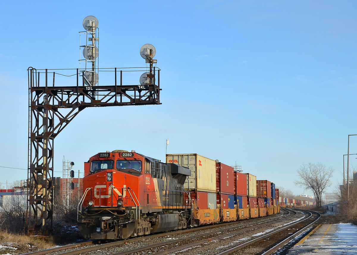 CN 2282 is shoving on the rear of CN 106 which is passing VIA's Dorval Station on a sunny winter afternoon.