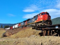 A southbound mixed freight is crossing the wooden trestle at Bretts Rd. behind a pair of Dash9's.