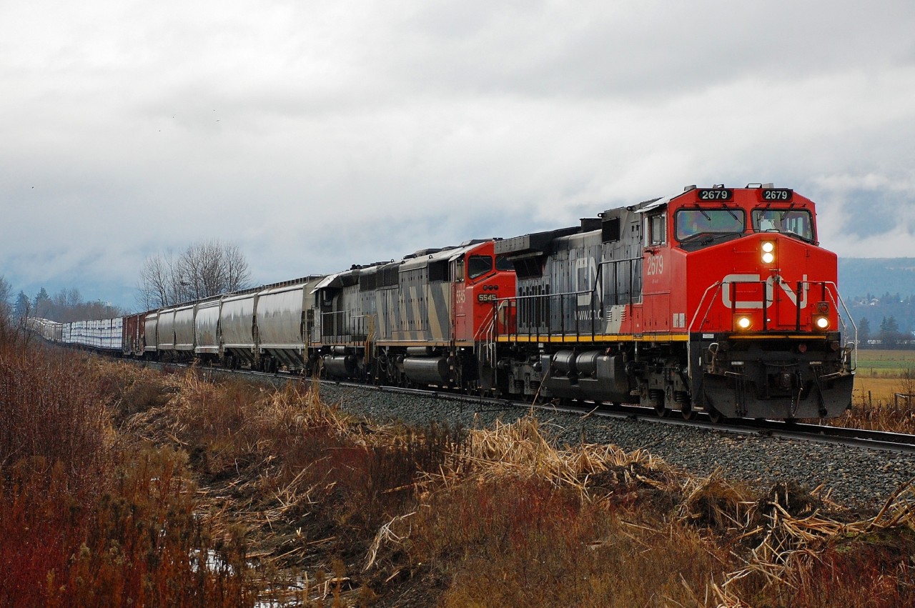 Light rain is falling as this interesting lash-up nears Armstrong with the local mixed freight.