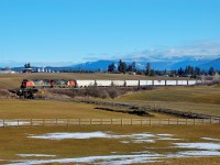 CN nos.2447&2648 are climbing out of Armstrong and are about to cross the wooden trestle over Bretts Rd. The first four cars are carrying wood pellets from the manufacturing plant located in downtown Armstrong.