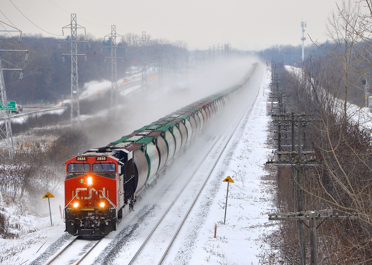 Grain train CN 878 has a solid set of 84 Saskatchewan Grain Car Corporation hoppers, along with 20 intermodal platforms on the tail end (lifted at Capreol). Power is CN 2855 at the head end and CN 3113 at the tail end.