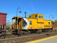 Multimarked caboose CP 434957 brings up the rear of a ballast train that is leaving Dorval.