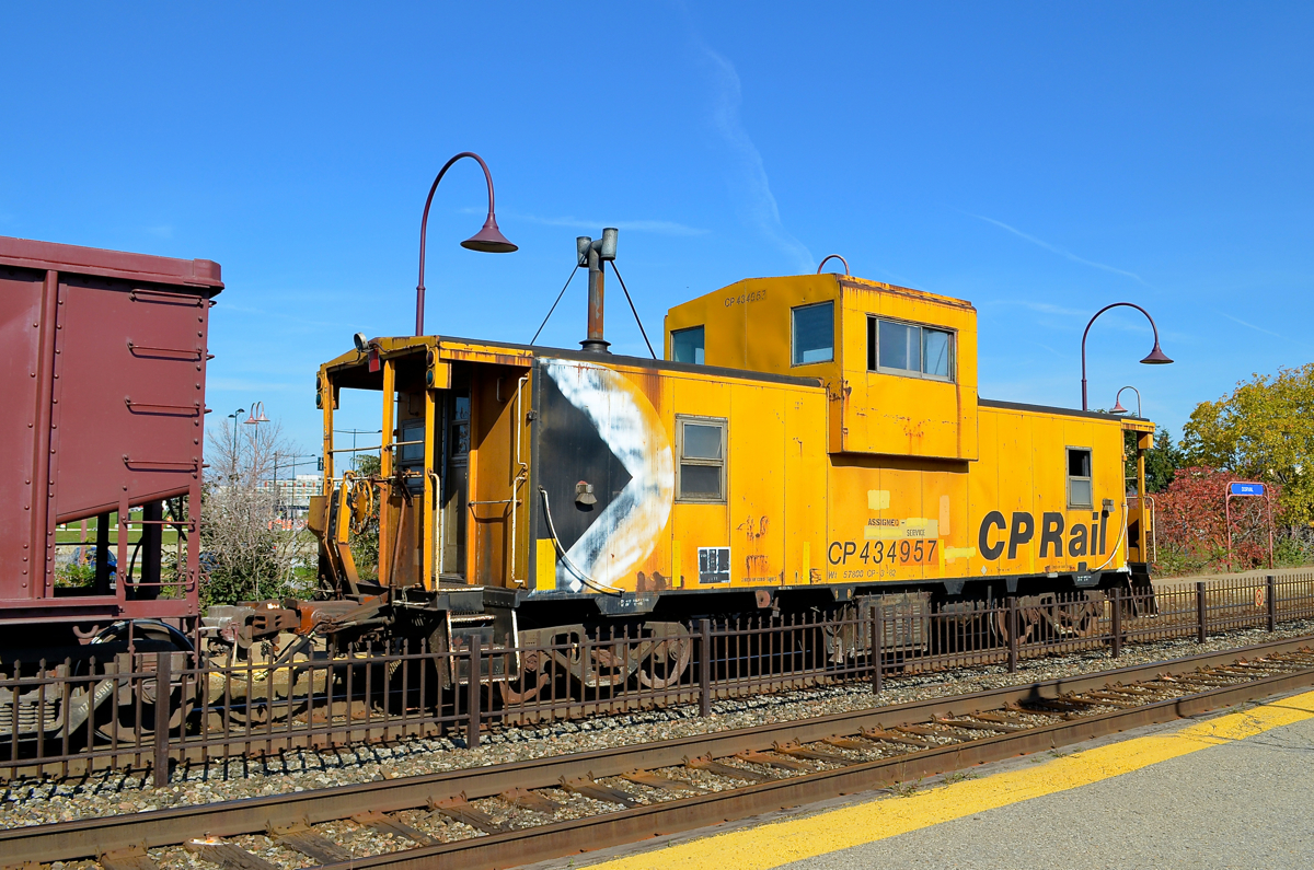 Multimarked caboose CP 434957 brings up the rear of a ballast train that is leaving Dorval.