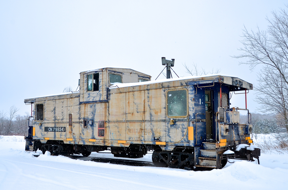 On a snowy Christmas eve, caboose CN 79834 is seen parked in Vankleek Hill on CN's Vankleek Spur. This caboose was built by CN in their Pointe St-Charles shop in Montreal under the same number. CN sold it to the Ontario L'Orignal Railway (OLOR) in 1996, which was taken over by the Ottawa Central Railway. In 2008 CN took over the Ottawa Central and renumbered the caboose back to its CN number. It is used for backup moves on the L'Orignal Spur and is in progressively worse shape.