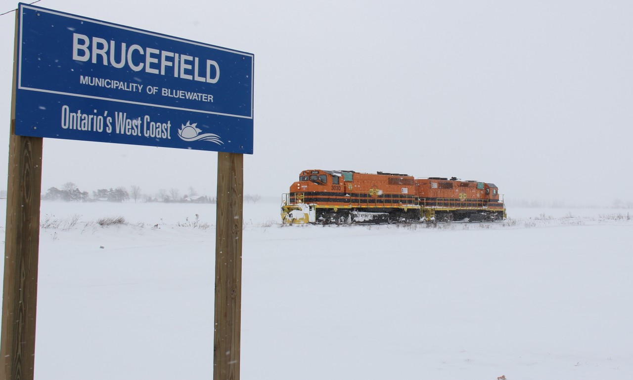 GEXR 3030 and 2303 trundle towards Clinton on the Exeter Sub on this blustery, wintery day. They are about to cross Mill Rd. at the community of Brucefield, as the sign denotes.