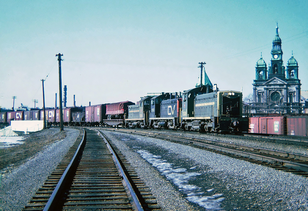 Central Vermont train 444 returning to Italy yard at St. Albans, Vermont, leading the train three EMD SW1200s two Grand Trunk Western numbers 1510 and 1503 and in the middle a Central Vermont No.1500. March 29, 1965.