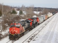 While Beachville maybe the lime capital of Canada, the railroads importance to hauling this commodity out of the area has diminished significantly over the years. We are looking east off the old steel road bridge at the east end of the quarry. At one point CN and CP tracks connected here at a small yard that served the eastern end of the quarry. A number of years ago CP quit serving the quarry, while CN only occasionally serves a load out at the west end of the quarry. The small yard here sits overgrown and unused, while the service track here buried under a cover of snow is sometimes used to store auto racks destined for the CAMI auto plant in Ingersol. CN 385 is seen racing westward at the quarry with a "Tier 3" and "Tier 4" GEVO for power. 