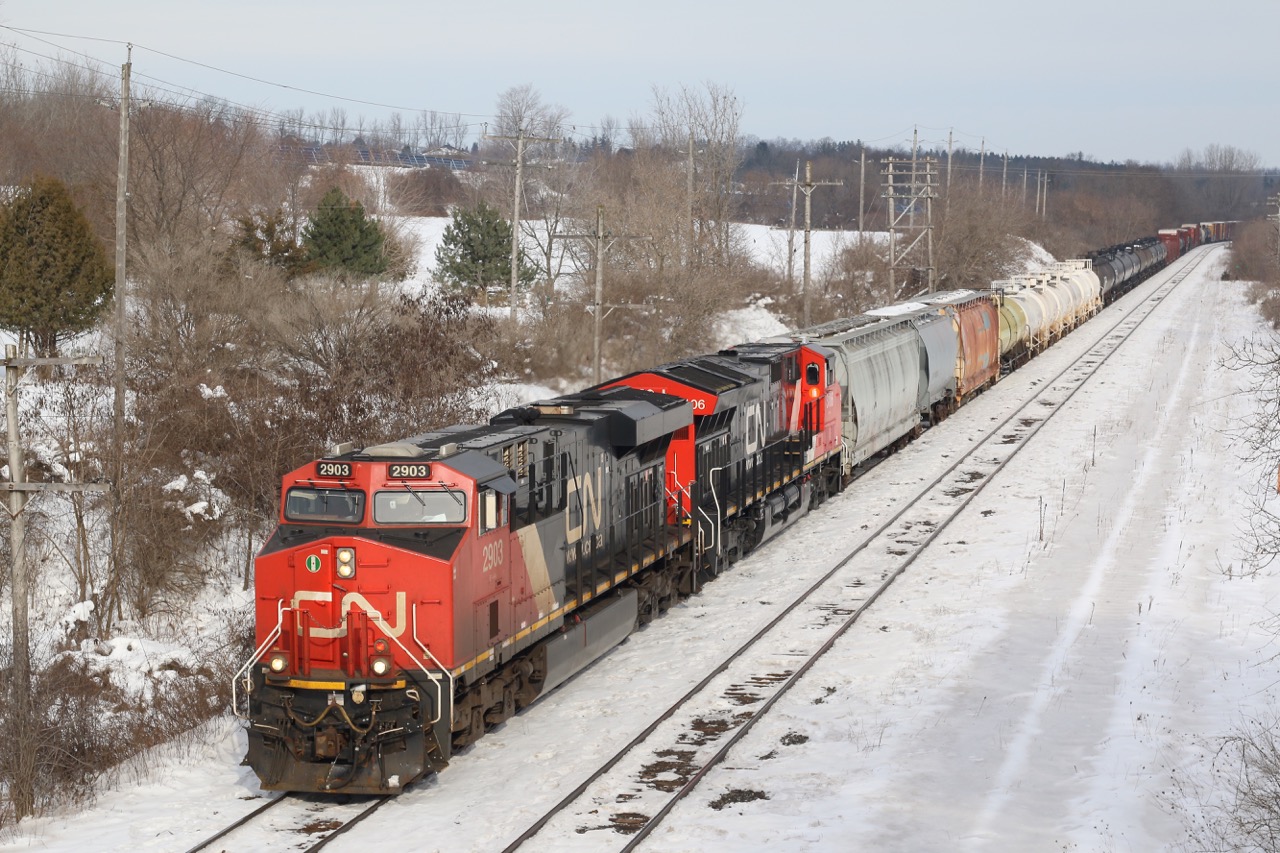 While Beachville maybe the lime capital of Canada, the railroads importance to hauling this commodity out of the area has diminished significantly over the years. We are looking east off the old steel road bridge at the east end of the quarry. At one point CN and CP tracks connected here at a small yard that served the eastern end of the quarry. A number of years ago CP quit serving the quarry, while CN only occasionally serves a load out at the west end of the quarry. The small yard here sits overgrown and unused, while the service track here buried under a cover of snow is sometimes used to store auto racks destined for the CAMI auto plant in Ingersol. CN 385 is seen racing westward at the quarry with a "Tier 3" and "Tier 4" GEVO for power.
