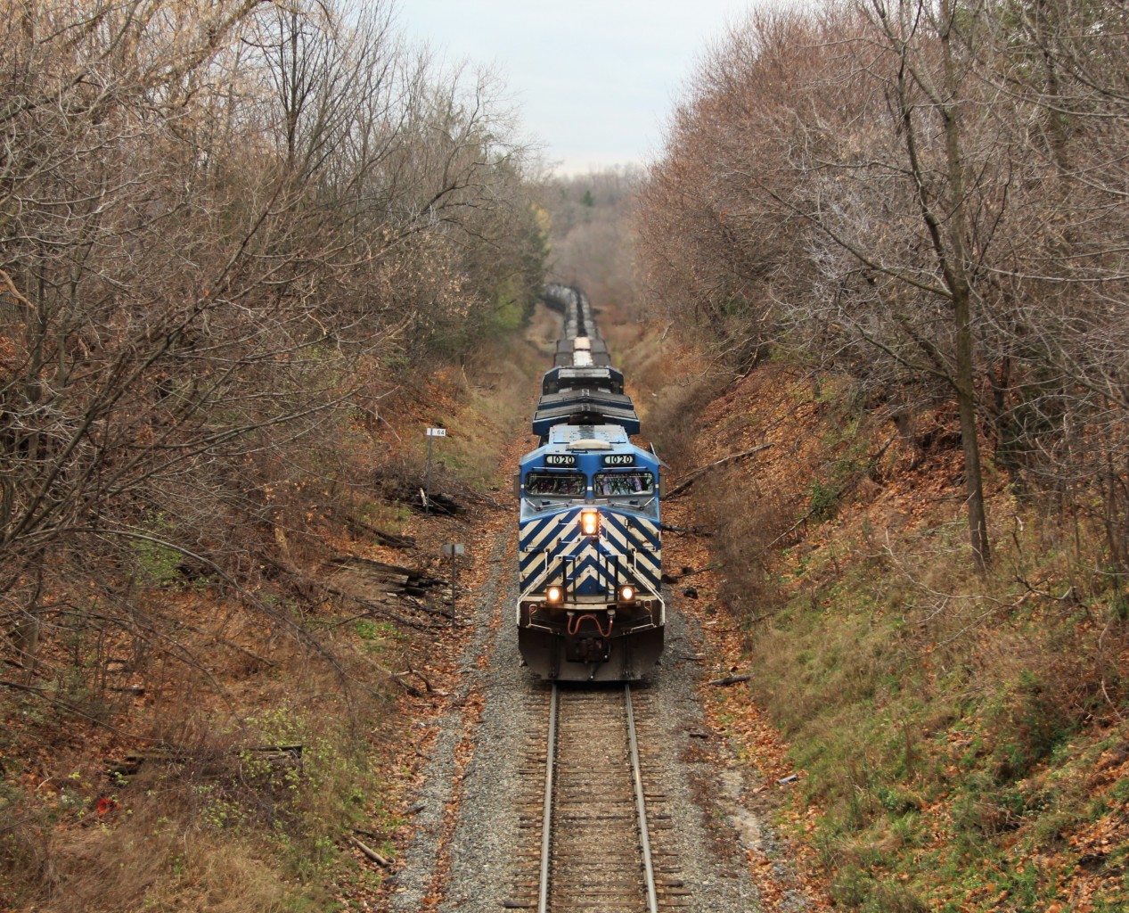 After a lengthy wait for a clearance, CEFX 1020 leads CEFX 1040 up the steep grade past MM 64 and under the Snake road wooden bridge in Waterdown on its way to Guelph Junction.
