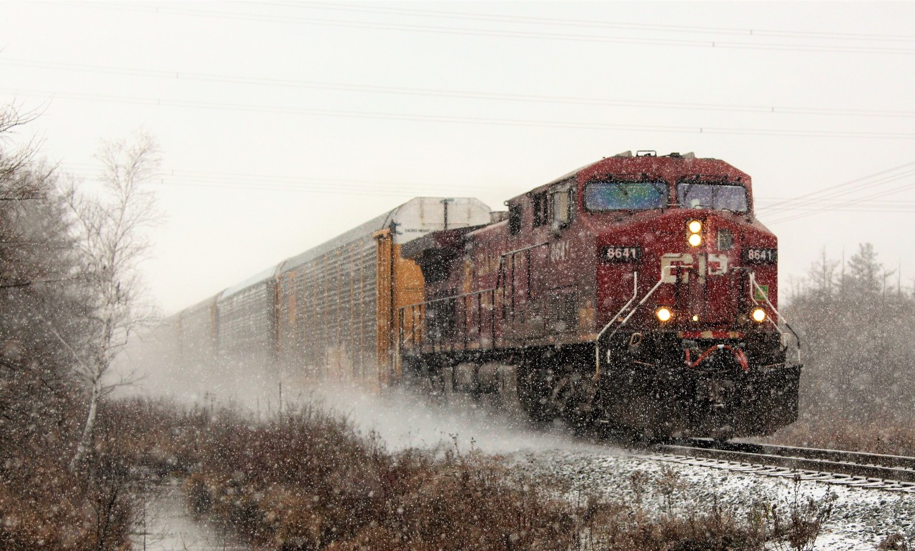 What was intended to be a regular shot on a dull day turned in to a shot in one the first snow squalls of the year in this area. Trying to keep the lens clear of snow and water drops turned out to be quite the chore as well. CP 8641 blasts its way through the snow across Concession 7 in Puslinch with clearance to Guelph Junction. It seemed odd to see a single engine for power on an over 7000 foot train when they regularly have been running two or three engines on 4000 foot or less over the last few months. That's CP for you.