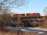 Canadian Pacific's bridge over the Credit River reveals a little history in the morning light, its piers were originally built by the Credit Valley Railroad to support a single track mainline. Later the second main was added but the new addition to the old pier was simply formed concrete instead of stone, and the newer truss didn't totally match the original design either. Here an eastbound with a pair of GE built locomotives thunder across the bridge on their way to Toronto yard.