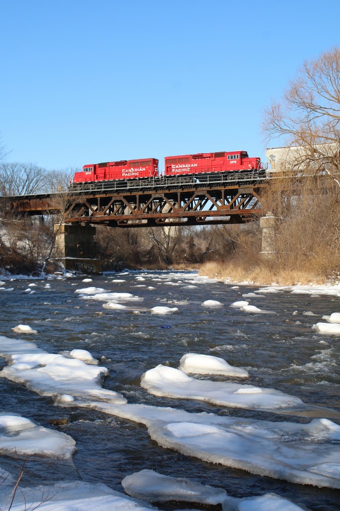 The sound of the constant flow of the Credit River is briefly drowned out by the sound of steel on steel as local T14 rattles across the old bridge over the river. Today there will be no stopping to work the large Ardent mill just west of the bridge, instead it's a strait run into Streetsville yard, with work on the branch as well.