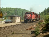 Due to the roar of some trucks on Hwy 144, I did not pick up the rumble of the train until it was almost upon me, but the conductor must have spotted me a ways off. I had seen him before, probably at Cartier station. Friendly feller. :o) His exuberance in my opinion adds a lot to the photo; CP 5993, 4700 and 4735 northbound passing Levack Station. On the extreme left you can see the INCO track leading in from the mine(s) at Onaping. Not sure what they use now, but back then I only saw GE electric 100 tonners. Behind me there is a small yard in which loads and empties are exchanged.