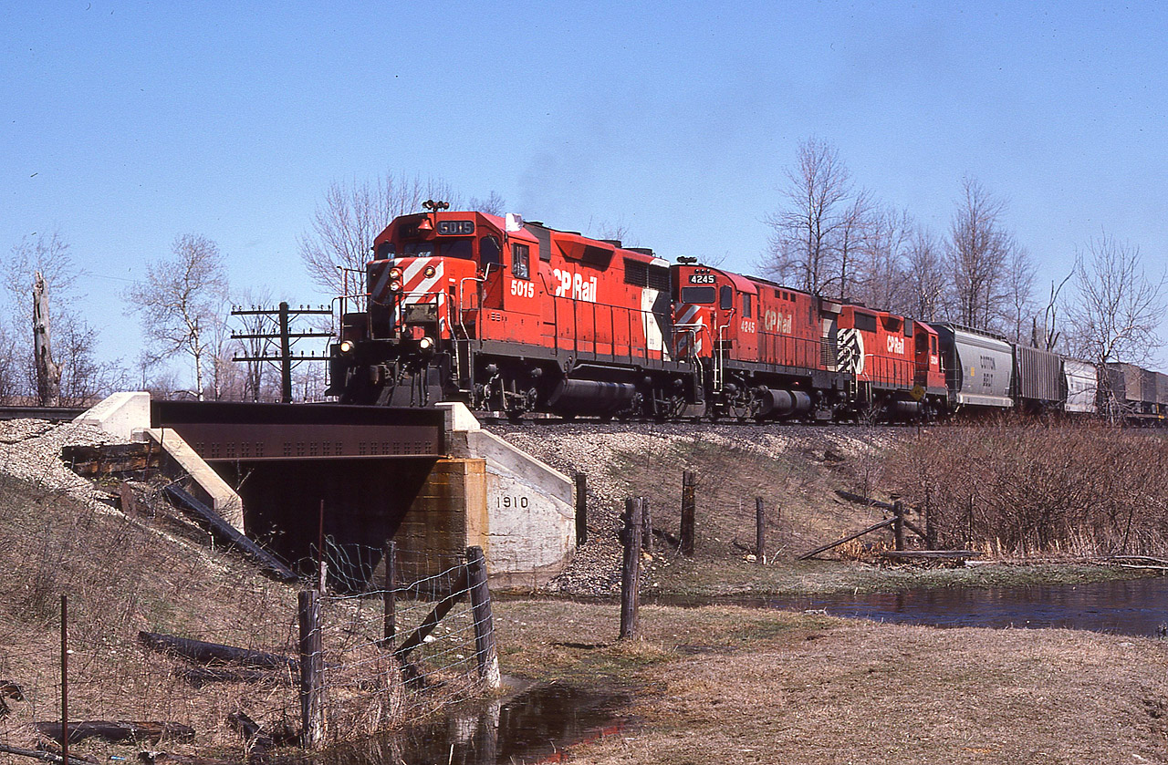 It is a beautiful spring day. The ground is still wet though. Extra westbound CP 5015, 4245 and 5024 made the day even nicer. The train worked a bit at the west end of Guelph Jct., enabling me to grab prints and slides of this general freight before it departed. In warmer and drier conditions I often spent time here along the diminutive Kilbride Creek, thoughts drifting to the possibilities of great lashups that never came. :o)