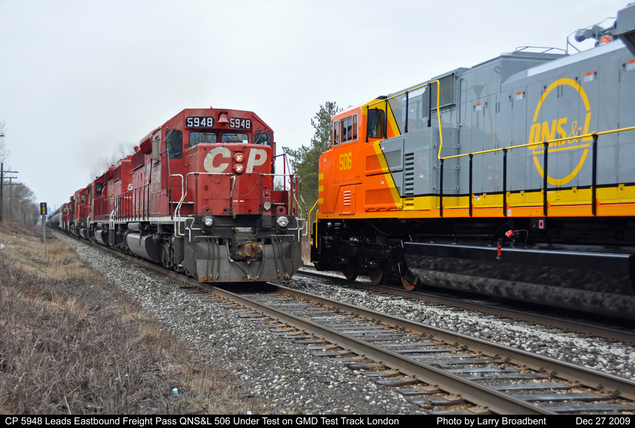 CP Eastbound lead by 5948 accelerates pass SD70ace QNS&L 506 undergoing testing on the GMD Test Track on a unusually warm day December 27 2009