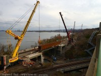 <b>First, a history lesson</b> The first railway bridge at this point was opened across the Desjardins Canal in 1855, as a swing bridge (!) but Canada's third worst Railway disaster occurred here in 1857, a Great Western Railway train crashed through the bridge into the icy Canal. It took two years to rebuild the bridge anew and the abutments are all that survives - the bridge having been modernised a couple times since. The TH&B/CPR added a second span in 1897 to cross over to the other side of Burlington Heights to connect the TH&B to Toronto. A third span was <a href=http://www.railpictures.ca/?attachment_id=25056 target=_blank> added in 1993 (Reg Button photo)</a> for the GO Hunter St expansion. <br><br>
In this photo cranes from Mammoet are lifting the fourth Railway span - a new 104 foot, 206,000 lb structure into place, with welders from the Ironworkers Local 736 ready to start work as soon as the bridge rests on its new footings. This bridge span was constructed in North Bay by <a href=http://www.centralwelding.ca/ target=_blank>Central Welding and Iron Works</a> and the project is funded by Metrolinx as part of the James St North and Niagara Region GO improvements.<br><br>
How long did it take to lift the bridge off that waiting truck and place it on footings? 10 minutes. That's it. I was simply in the right place at the right time - having gone down for the Xmas train scheduled to depart at 1400. <br><br>
Note: Research to find information used in this caption was performed by the Author. Please credit appropriately if this information is used elsewhere as considerable effort went into this caption. Thank you.
