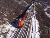 From high above the tracks at mile 4 Dundas sub, this scene with westbound CN 3151, 3150 Tempo train was a nice image on a cold almost-winter morning. The overhead conveyor belt structure (Canada Crushed Stone) from which I took this photo was dismantled more than 20 years ago, making this a somewhat historical image.  That is the Sydenham Rd bridge in the background.