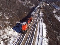From high above the tracks at mile 4 Dundas sub, this scene with westbound CN 3151, 3150 Tempo train was a nice image on a cold almost-winter morning. The overhead conveyor belt structure (Canada Crushed Stone) from which I took this photo was dismantled more than 20 years ago, making this a somewhat historical image.  That is the Sydenham Rd bridge in the background.