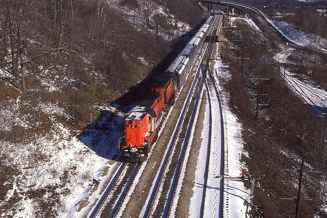From high above the tracks at mile 4 Dundas sub, this scene with westbound CN 3151, 3150 Tempo train was a nice image on a cold almost-winter morning. The overhead conveyor belt structure (Canada Crushed Stone) from which I took this photo was dismantled more than 20 years ago, making this a somewhat historical image.  That is the Sydenham Rd bridge in the background.