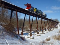The railways in Tillsonburg seems to be defined by the bridges that cross the Big Otter Creek and the namesake valley. The St. Thomas and Eastern quit operating in 2013 mostly on account of the three large bridges in the area. But it's 2016, CN has decided to fix the Cayuga sub bridges, and it would seem that OSR is imminently to stop operating over their bridge in Tillsonburg in favour of going the other way around via St. Thomas. While this is good news as OSR re-activates a rail line from St. Thomas to Tillsonburg (and to Courtland) the CPR bridge in Tillsonburg will soon cease to have trains - for now. I wouldn't say it's done for good, chances are OSR will fix it up in due time, but probably not for a while. Anything is possible, get your photos while you still can.<br><br>
History indicates this structure was built around 1897 when the CPR built a 'loop line' to reach the CASO. For a year or two prior, the Tillsonburg, Lake Erie and Pacific railway used 3 miles of the GTR plus their station to access Tillsonburg. Corrections always appreciated and welcome. Merry Christmas everyone!

