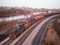 This was the very first run of the TH&B/CP Nanticoke Steel Train, which run via Hamilton to Brantford and southward over the old TH&B line on November 7, 1983. The power, leased units from the 'Chessie System', on this occasion were B&0 4815, C&0 3885 and C&0 4828. The run went smoothly. Because the marked time of around 1430 out of Hamilton was worrisome for any photographers that ventured as far as Waterford, it was almost a miracle of sorts when the sun popped out at exactly the right time while I was up on the old LE&N High Bridge watching this train, which had just come off the Wye heading west, backing up into town to cross over and head back south on the track visible at the right hand side in this image, thereby continuing on to Nanticoke having crossed the old CASO without the benefit of the Out of Service bridge.  By the time the train was heading back south, darkness ensued and for photos, it was game over. Visible in this shot, besides all that trackage that is now nothing but hiking trails, is the north part of Waterford in the background. The town is spliced by the Nanticoke Creek, and to the left and mostly out of the photo, the Waterford Ponds. It is a nice area, the station is out of sight around the bend and still exists as a commercial enterprise.