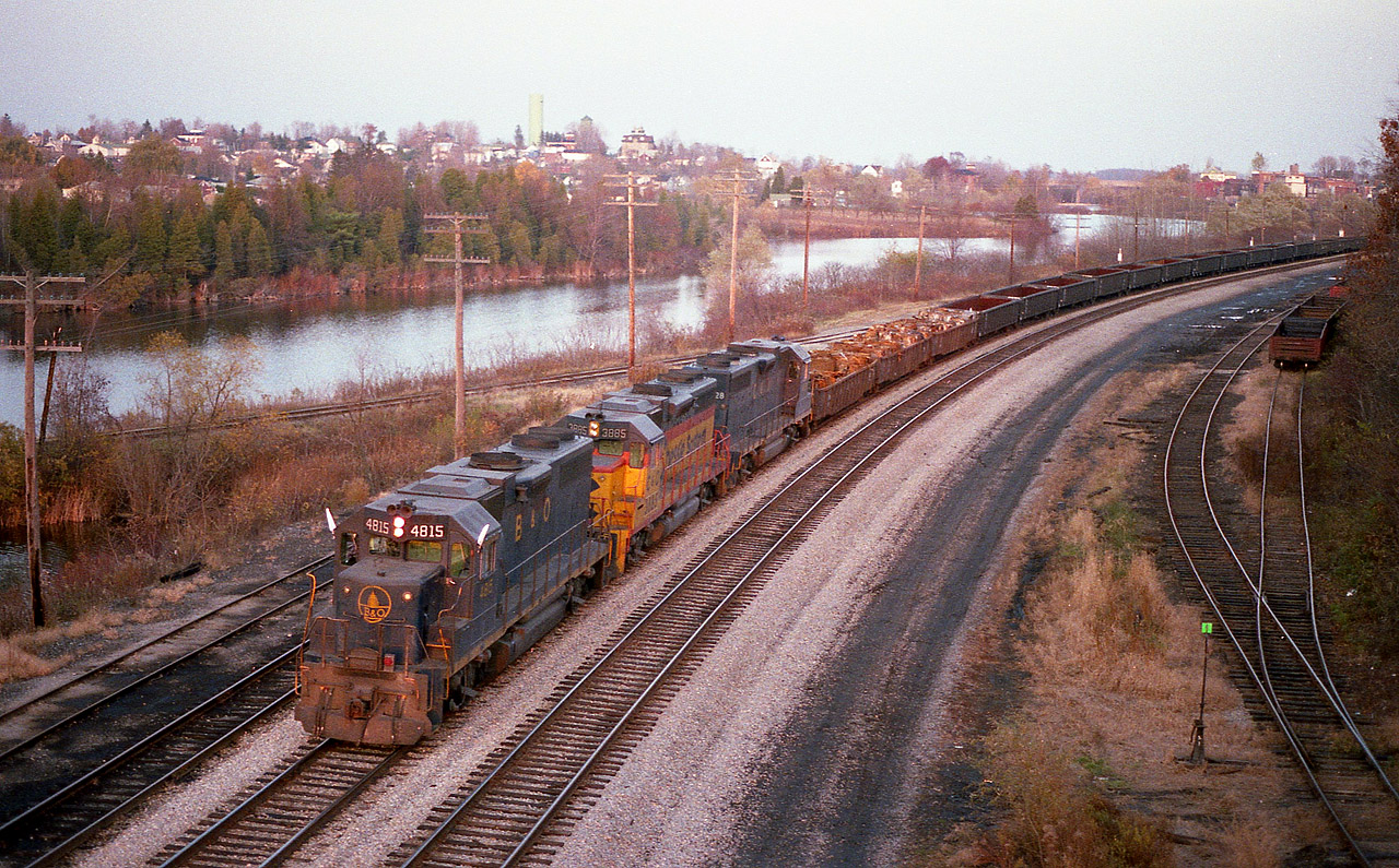 This was the very first run of the TH&B/CP Nanticoke Steel Train, which run via Hamilton to Brantford and southward over the old TH&B line on November 7, 1983. The power, leased units from the 'Chessie System', on this occasion were B&0 4815, C&0 3885 and C&0 4828. The run went smoothly. Because the marked time of around 1430 out of Hamilton was worrisome for any photographers that ventured as far as Waterford, it was almost a miracle of sorts when the sun popped out at exactly the right time while I was up on the old LE&N High Bridge watching this train, which had just come off the Wye heading west, backing up into town to cross over and head back south on the track visible at the right hand side in this image, thereby continuing on to Nanticoke having crossed the old CASO without the benefit of the Out of Service bridge.  By the time the train was heading back south, darkness ensued and for photos, it was game over. Visible in this shot, besides all that trackage that is now nothing but hiking trails, is the north part of Waterford in the background. The town is spliced by the Nanticoke Creek, and to the left and mostly out of the photo, the Waterford Ponds. It is a nice area, the station is out of sight around the bend and still exists as a commercial enterprise.