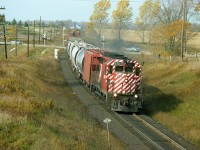 Beautiful windy fall day out there as local CP 5017 (GP35) heads into Woodstock eastward with a short train. The train is crossing Hwy 2, which certainly doesn't look like a provincial highway, seeing such minimal protection at the crossing ........and this location is somewhat obscured when approaching from the west due to a dip in the roadway.  I am standing on a farm laneway overpass, an old wooden structure that serves about 3 farmhouses. This particular bridge was replaced by a modern steel one a few years ago. I very rarely shoot here as it IS private property. Pleasant local citizens, thankfully.