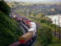 Action Central!!! Yep. Thats what it was like around Bayview during the dinner hour some years ago. Behind me the CN local was working the Hamilton Stuart St yard, the Budds for Niagara had just passed, as had the GO running east with 902/706. And I happened to be in the right spot because I heard the "Goderich" coming down from Waterdown so zipped over to the High Level bridge from Bayview to grab a shot of it. To my surprise, out comes the TH&B Starlite, with CP 5699 and 5790. As CP 8756 passes heading into Aberdeen, the Starlite, which runs to Toronto via the CN, has to wait because here comes the Dofasco Ore train! A couple of passengers up and down the Dundas Hill as well as a freight further complicated this rather productive hour. Sure do not experience days like this any more. Ore train power is: CN 9550, 9582, 9453, 4006 and 5045.