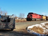  A CP AC4400 and a UP GEVO lead a mixed freight through the small town of Baxter Ontario while rail maintainers wait off to the side in their truck.