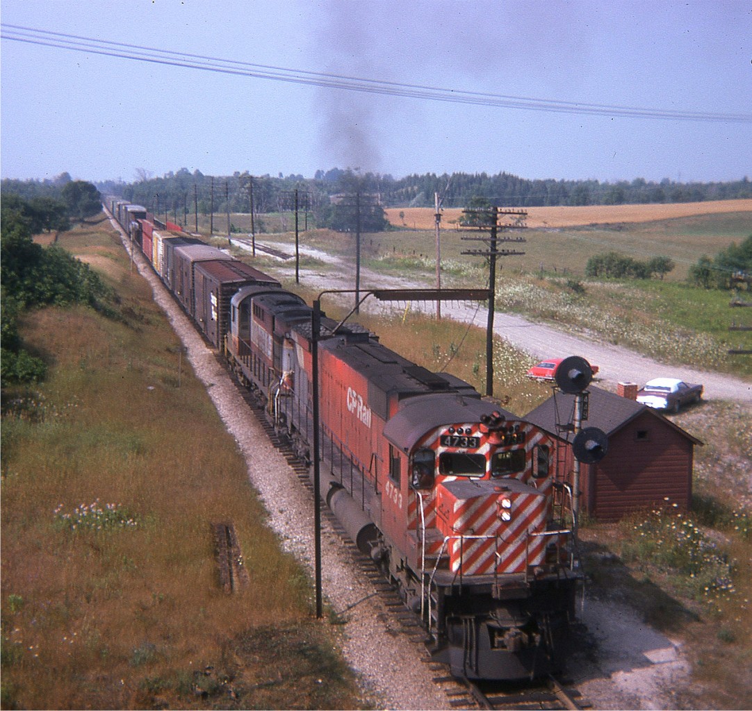 This was once the site of a very nice old Puslinch train station. I believe it disappeared in the mid 1960s, and all there is now is a MoW shed and signal as seen in this view from the side of Hwy 6, taken 42 years ago as of this posting. Power on this eastbound, moving at speed, is CP 4733 and 8599, still in old paint scheme. When I look over this scene, it brings back the feelings of the much less stressful years...........