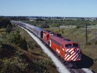 CP FP7 #4069 leads GP9 8512 and the 10 cars of the Toronto section of The Canadian through the rolling landscape near Bolton, ON on 9/4/1978