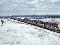 4 TH&B GP-7's with a CP MLW tucked in behind working hard on the final leg of the climb up the Escarpment on February 28, 1982.  Thanks to other posts in the database I've learned that this was a unit rock train for a fertilizer plant in Port Maitland.  We were counting on the clear skies that were forecast when we left Cleveland in the middle of the night but we saw quite a show in spite of the mid day clouds that caught up with us here at Vinemount.                          