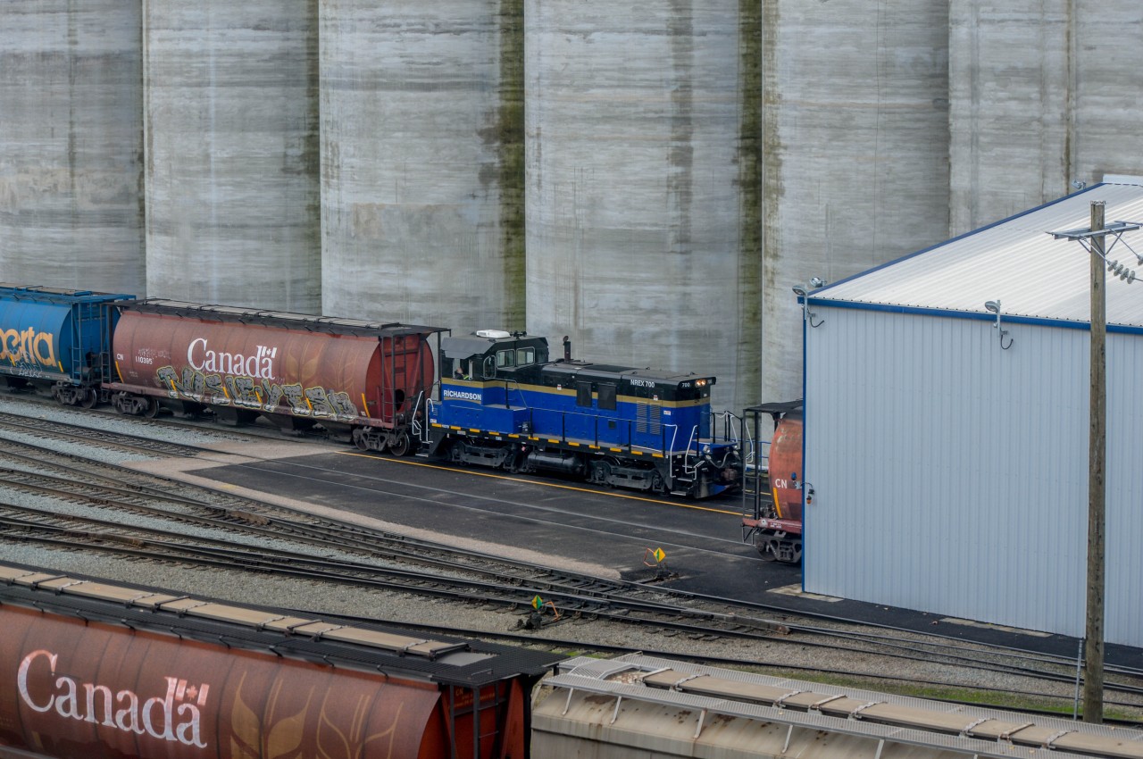 NREX 700, a NRE 1GS7B, waits outside the dumper at Richardson Pioneer grain terminal, which is within CN's Lynn Creek Yard Terminal. The engineer seems to be having a nice nap.