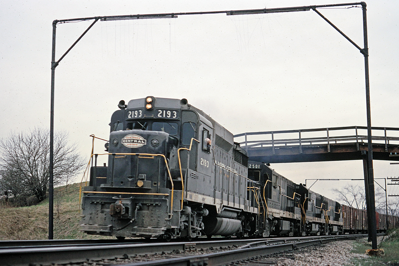 NYC NY4 was always identifiable by the stock cars at the head end.  Here, GP30 2193 is leading 3 GE U25B's as the train rounds the curve under the wooden farm bridge at Clanbrassil on the old Michigan Central.