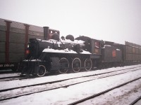 CN #96 was a Mogul (2-6-0) built in 1910. Began as GT 1024, then to 926, and after merger with CN became their 96. It was on display in Steamtown when that collection was located near Bellows Falls, VT by the Connecticut River. When the man behind this venture, Nelson Blount, died, the whole collection became in limbo and resulted in Steamtown being relocated to Scranton, PA as we know it now. The CN 96 was deemed non-essential and as a result was obtained by Horst Muller of Ontario. As far as I know the locomotive was heading for an enginehouse in Preston. And as far as I knew I was going to catch it enroute. This February morning was a real stinker, damp, dark, dull, foggy as all get out, and upon arriving at Fort Erie to wait for it, I felt it was a lost cause. However, with the 'Sidekick' in tow for company, we walked the yard killing time and there it was!!! Not easy to see until one was within 6 or 7 carlengths. So this is the resulting photo. Deep within the yard. I am not sure who else might have caught it, if anyone, oddly enough the fog became even more dense as the morning wore on, and either the engine was hauled out during said fog or under cover of darkness, because the next morning it was gone. I did not hear another peep about it other than a couple of magazine comments that it was actually in Ontario. Someone said it went to Waterford but I was unable to find it. Then I heard it was in Brantford. Yep. Decaying away behind a fenced off area looking so poorly as if it had no future. It languished a few years there. Ignored. In 1994 it was rescued, and went back to the United States where it became the property of the Ohio Central based in Morgan Run Ohio; not far from Brewster. It is currently on display, non-operative.