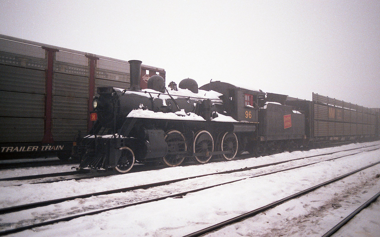 CN #96 was a Mogul (2-6-0) built in 1910. Began as GT 1024, then to 926, and after merger with CN became their 96. It was on display in Steamtown when that collection was located near Bellows Falls, VT by the Connecticut River. When the man behind this venture, Nelson Blount, died, the whole collection became in limbo and resulted in Steamtown being relocated to Scranton, PA as we know it now. The CN 96 was deemed non-essential and as a result was obtained by Horst Muller of Ontario. As far as I know the locomotive was heading for an enginehouse in Preston. And as far as I knew I was going to catch it enroute. This February morning was a real stinker, damp, dark, dull, foggy as all get out, and upon arriving at Fort Erie to wait for it, I felt it was a lost cause. However, with the 'Sidekick' in tow for company, we walked the yard killing time and there it was!!! Not easy to see until one was within 6 or 7 carlengths. So this is the resulting photo. Deep within the yard.  I am not sure who else might have caught it, if anyone, oddly enough the fog became even more dense as the morning wore on, and either the engine was hauled out during said fog or under cover of darkness, because the next morning it was gone.  I did not hear another peep about it other than a couple of magazine comments  that it was actually in Ontario. Someone said it went to Waterford but I was unable to find it. Then I heard it was in Brantford. Yep. Decaying away behind a fenced off area looking so poorly as if it had no future. It languished a few years there. Ignored. In 1994 it was rescued, and went back to the United States where it became the property of the Ohio Central based in Morgan Run Ohio; not far from Brewster. It is currently on display, non-operative.