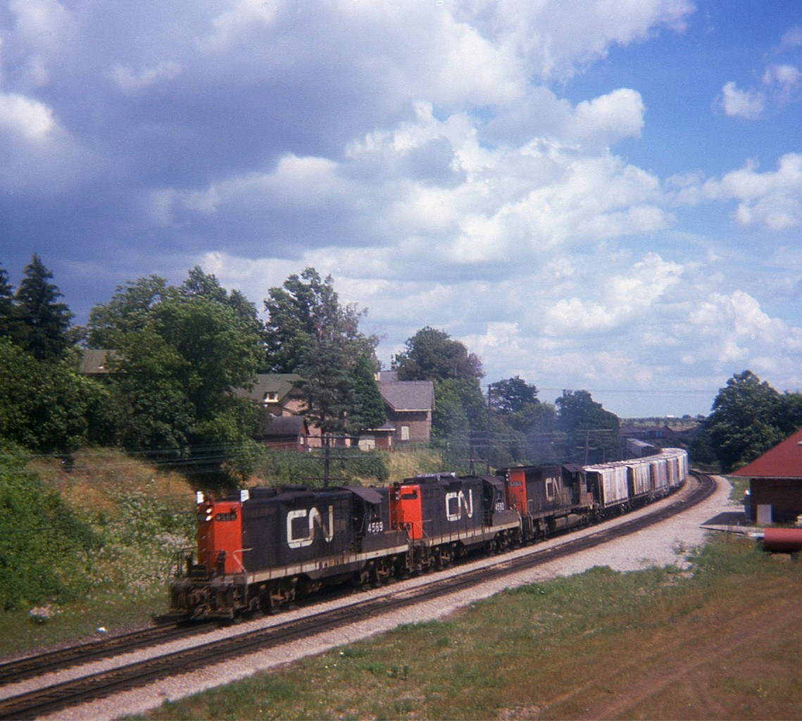 Back in the summer of 1974 on a beautiful day we see CN 4569, 4592 and 5050 westbound past the location of the old Paris station. This image was taken from the side of John St where it passes over the CN main. The end of train caboose is barely visible on the other side of the huge Grand River bridge, a Paris landmark.