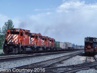 In June 1986 I was returning home from Jasper to Edmonton when I encountered a detouring westbound CPR intermodal train. I quickly turned around and gave chase. I caught up to it at Bickerdike where conveniently there was a parked CN van to give some context. 