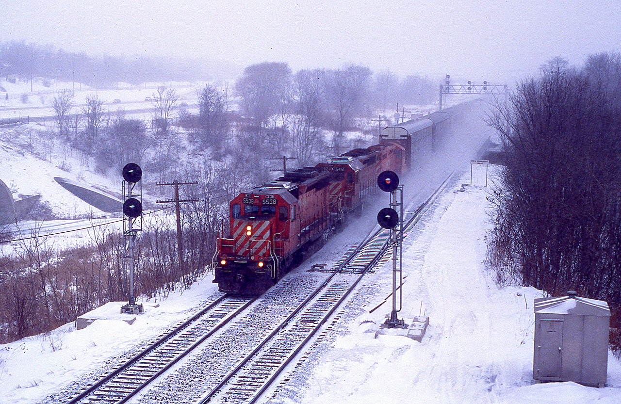 Back when CP used to exercise running rights over the CN along the Oakville sub we see what I believe is #522. Toronto to Buffalo.  This image was taken off the Lemonville Rd bridge in Aldershot, once a favourite location for trainwatching on account back then there was little road traffic and plenty of rail traffic. These days, it is the other way around. CP 5538, 5412 and 8241 is the power for this train, running at speed thru light blowing snow. All units now off the CP roster, the 5412 is X-QNSL 216.
