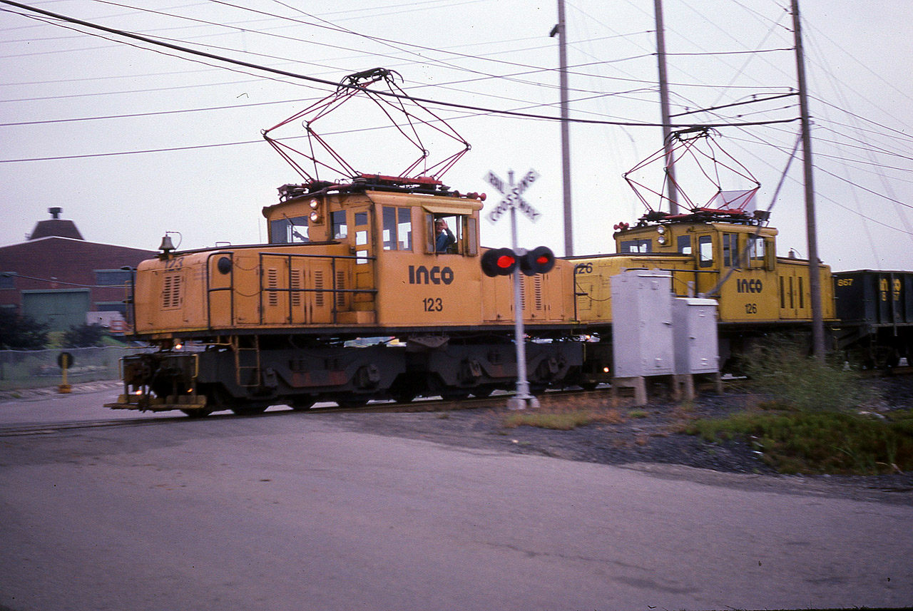 It was tough to catch these electrics on the job.  Not only did they really move, the roads did not go where they did, and a shot or two was best one could expect without being 'trapped' on private property. INCO 123 and 126, captured here heading westbound, were 85 Tonners, built 1942 and 1950 respectively; originally were Kennecott Copper 62 and 63. They were both retired and stored in Sudbury along with the rest of the electric fleet when the company 'upgraded' to diesel GP38s around 2001. I would have thought electric would have been cheaper to run, but these motors were getting rather on in years. Since this photo was taken, the company has changed from INCO to CVRD Inco, and now Vale Inco. I still prefer the old name, International Nickel.