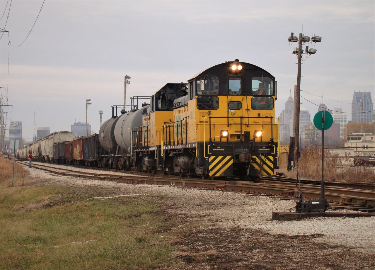 With downtown Detroit looming in the background we see Essex Terminal SW8 105 and SW14 104 haul 39 cars through the ETR-CP interchange yard, where they will drop a handful of cars from ADM for CP before heading over to CN for interchange. The train consists of two alcohol cars from Hiram Walkers-which were picked up that morning- five gondolas to be interchanged with CN bound for Zalev Bros Scrap and 32 cars from ADM after a morning of switching on Windsor's west side.