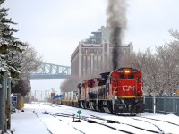 <b>Got GE smoke?</b> C40-8 CN 2039 belches smoke as it prepares to leave the Port of Montreal with CN 149 and 12,200 feet of platforms on the drawbar. Trailing are two more interesting GE units - BCOL 4642 & CN 2420.